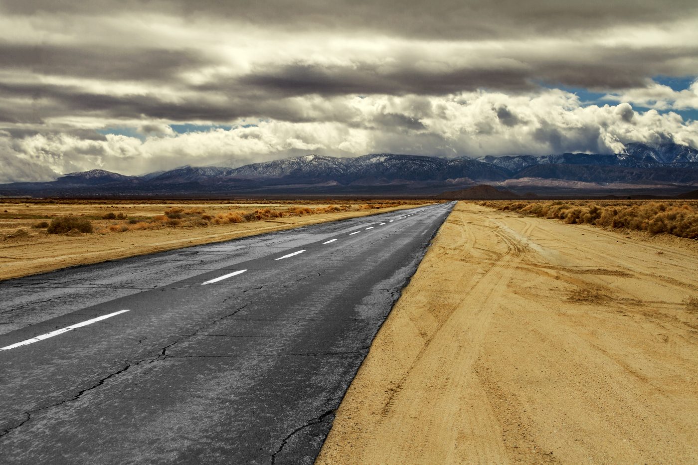 A long desert highway running toward mountains under an open Nevada sky near Beatty